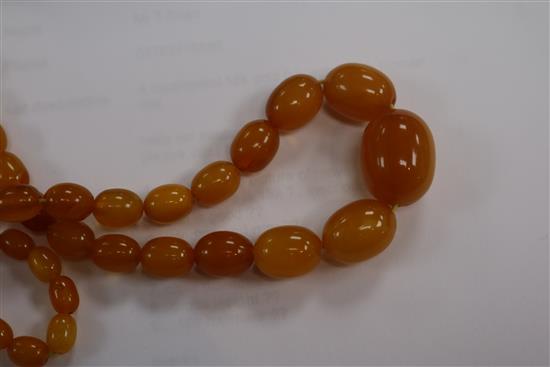 A single strand amber bead necklace, 28grms and an amber cigar holder.